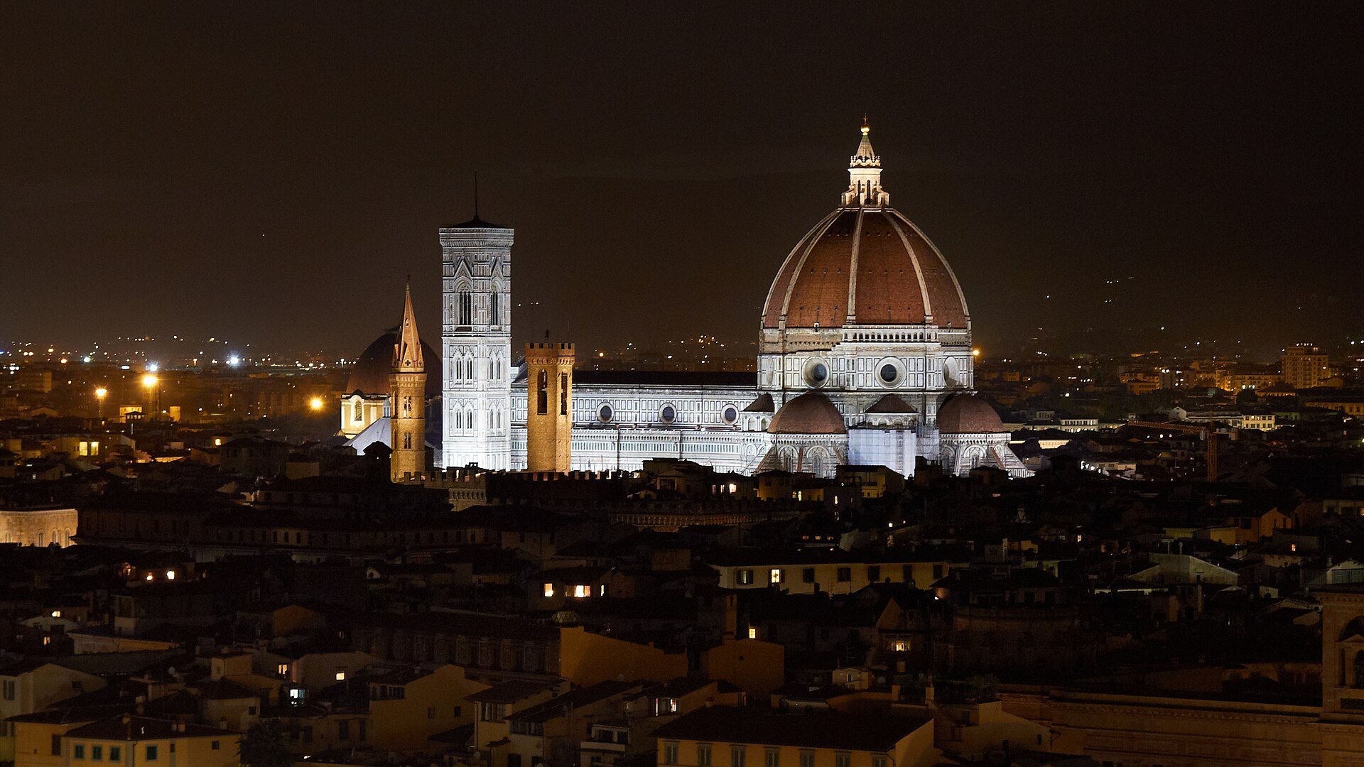 The red dome of Florence Cathedral rising above terracotta rooftops under a clear sky