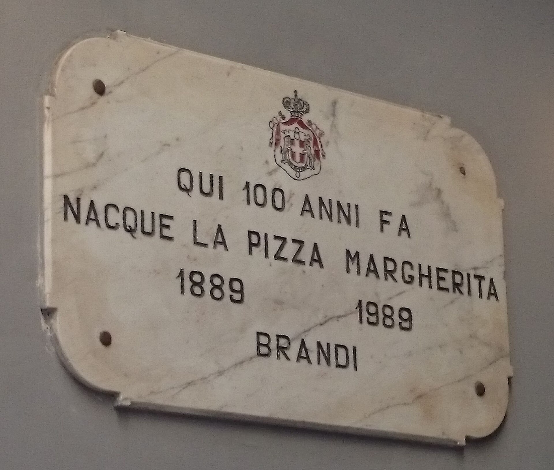 A wood-fired Pizza Margherita with charred cornicione, the centerpiece of any Naples food guide
