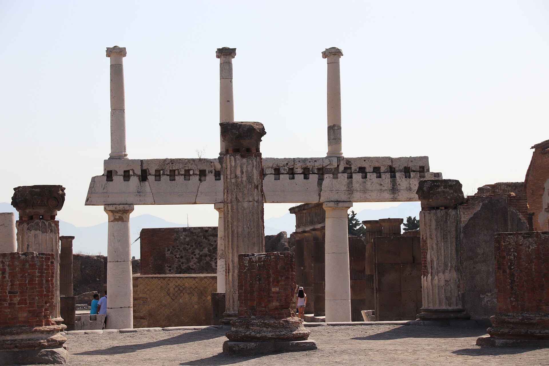 Ancient Forum columns at Pompeii with volcanic stone paving and temple remains