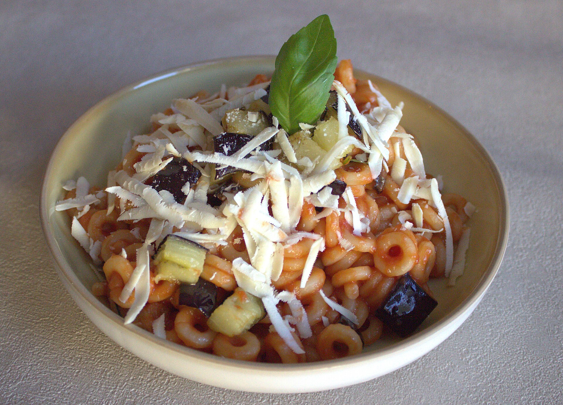 A bowl of pasta alla Norma with fried eggplant, tomato and grated ricotta salata