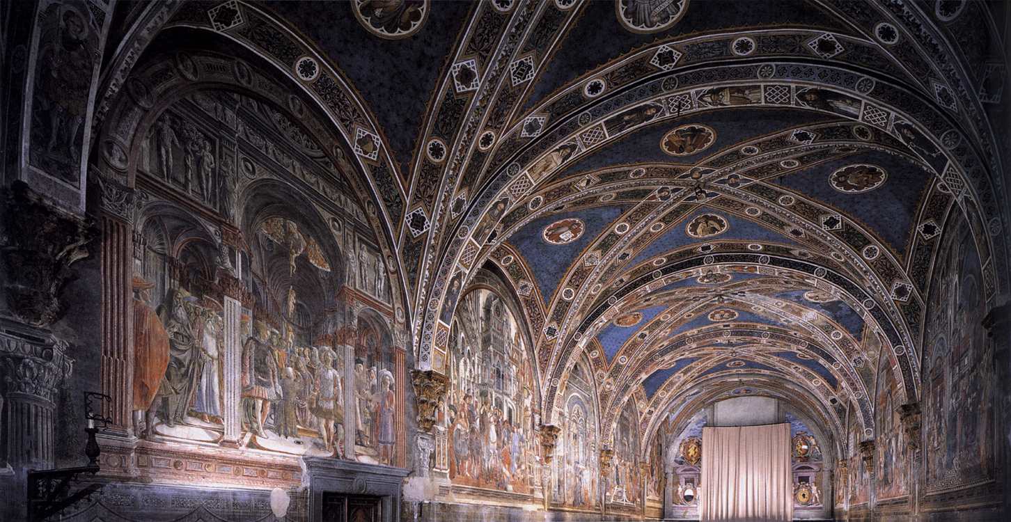 Inside the Pellegrinaio hall of Santa Maria della Scala — the 15th-century frescoes cover every wall with scenes from the hospital's daily life